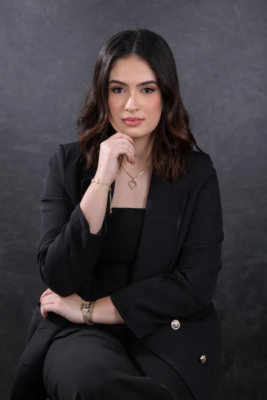 Advogada com postura confiante, vestida formalmente, representando a advocacia e consultoria jurídic.